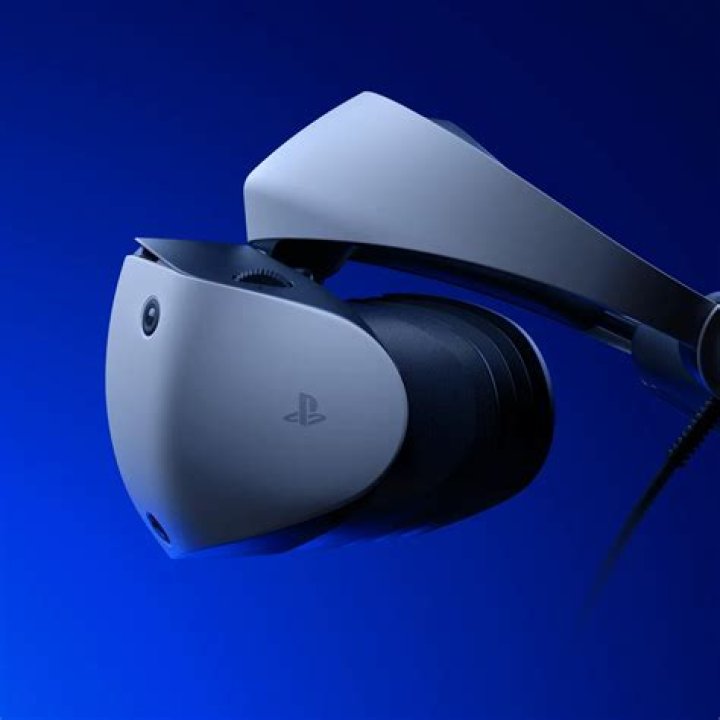 The PlayStation VR2 headset with the Pulse 3D wireless headphones placed on top of it.